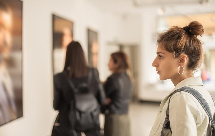 一位年轻女子在艺术博物馆里看一幅画